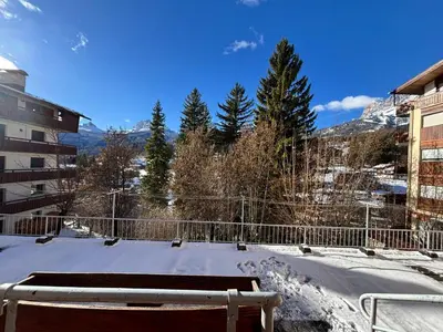 a snow covered yard with a fence and trees at Casa Varentin, in the center of Cortina in Cortina dʼAmpezzo