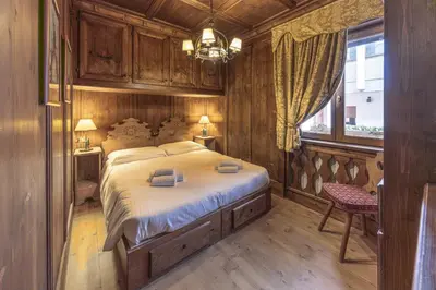 a bedroom with a large bed and a window at Casa Verzi, comoda e confortevole in pieno centro in Cortina dʼAmpezzo