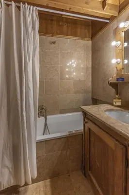 a bathroom with a bath tub and a sink at Casa Verzi, comoda e confortevole in pieno centro in Cortina dʼAmpezzo