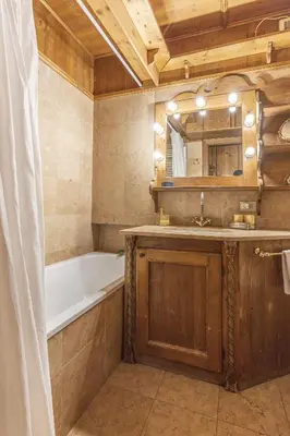 a bathroom with a bath tub and a sink and a bath tub at Casa Verzi, comoda e confortevole in pieno centro in Cortina dʼAmpezzo