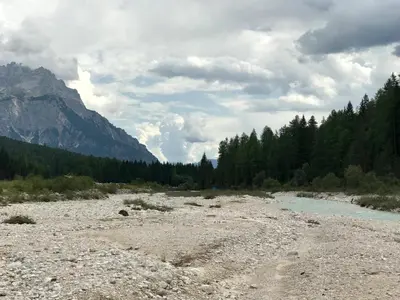a river in the middle of a mountain with trees at Brand new beautiful ground floor flat in Cortina dʼAmpezzo