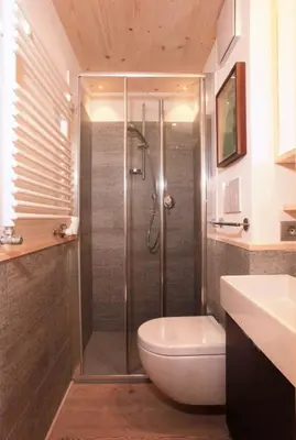 a bathroom with a shower with a toilet and a sink at Brand new beautiful ground floor flat in Cortina dʼAmpezzo