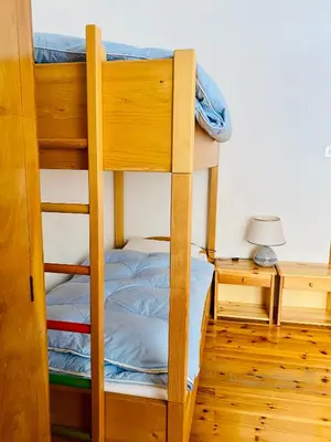 a bunk bed in a room with a table and a lamp at Zirmo mountain home in Carano