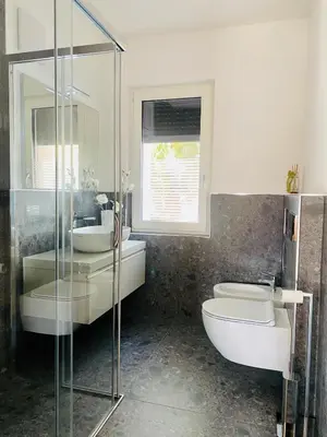 a bathroom with a toilet and a sink and a tub at Zirmo mountain home in Carano
