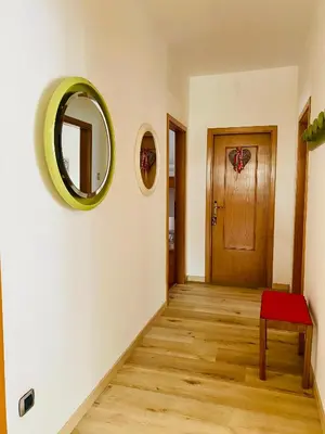 a hallway with a door and a mirror on the wall at Zirmo mountain home in Carano