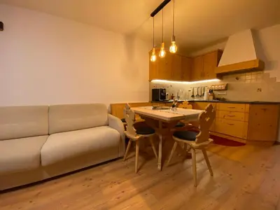 a living room with a couch and a table at dolomites view apartment 2 in Rasun di Sopra
