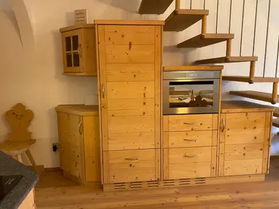a wooden cabinet with a microwave on top of it at dolomites view apartment 2 in Rasun di Sopra