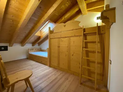 a bedroom with a bed and a bunk bed in a room at dolomites view apartment 2 in Rasun di Sopra