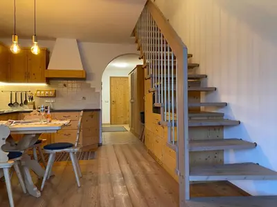 a staircase in a kitchen with a table and a counter at dolomites view apartment 2 in Rasun di Sopra