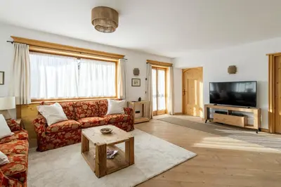 a living room with a couch and a tv at Chalet Chiave - Prenotazioni Dirette Dolomiti Skyline in Cortina dʼAmpezzo