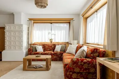 a living room with a couch and a table at Chalet Chiave - Prenotazioni Dirette Dolomiti Skyline in Cortina dʼAmpezzo