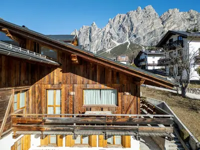 a wooden house with mountains in the background at Chalet Chiave - Prenotazioni Dirette Dolomiti Skyline in Cortina dʼAmpezzo