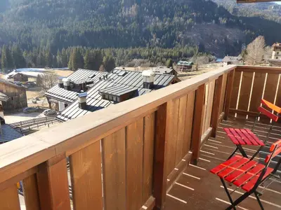 two red chairs sitting on a deck with a view at Casa Tomà Mountain View Cortina in San Vito di Cadore