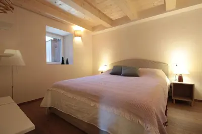 a bedroom with a bed with two lamps and a window at Casa Tomà Mountain View Cortina in San Vito di Cadore