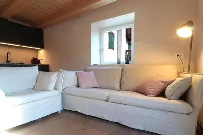 a living room with a white couch with pillows on it at Casa Tomà Mountain View Cortina in San Vito di Cadore
