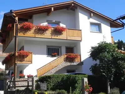 a white building with flower boxes on balconies at Tai Bedoes in Moena
