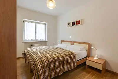 a white bedroom with a bed and a window at Tai Bedoes in Moena