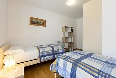 a bedroom with two beds and a book shelf at Tai Bedoes in Moena