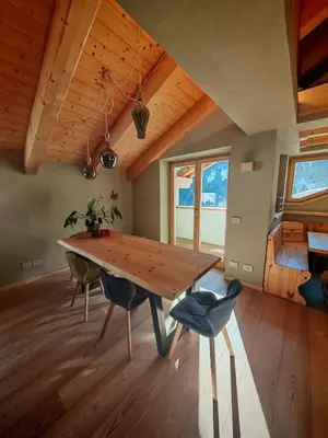 a dining room with a wooden table and chairs at Selva loft in Selva di Cadore