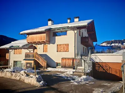 a large house with snow on the side of it at Selva loft in Selva di Cadore