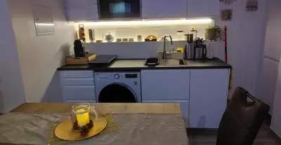 a kitchen with a table with a glass of orange juice at Blätterbett - letto di foglie in Bolzano