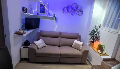 a living room with a couch and a tv at Blätterbett - letto di foglie in Bolzano