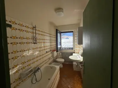 a bathroom with a tub and a toilet and a sink at Passo Carezza Club Apartment in Carezza al Lago