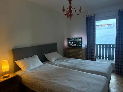 a bedroom with a bed and a television and a window at Passo Carezza Club Apartment in Carezza al Lago