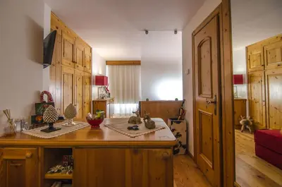 a kitchen with wooden cabinets and a counter with figurines on it at Monolocale in centro a Cortina in Cortina dʼAmpezzo