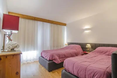 a hotel room with two beds and a window at Monolocale in centro a Cortina in Cortina dʼAmpezzo