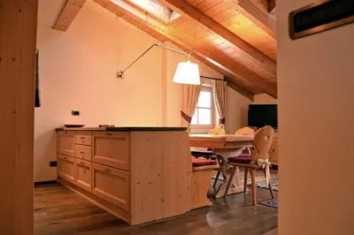 a kitchen with a table and a dining room at Casa Micol in Moena