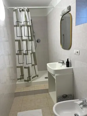 a bathroom with a sink and a shower curtain at Appartamento con terrazza in Bolzano