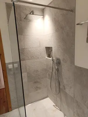 a shower with a glass door in a bathroom at Brunelle, Obertörgglerhof in Brixen