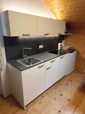 a kitchen with white cabinets and a sink at Brunelle, Obertörgglerhof in Brixen