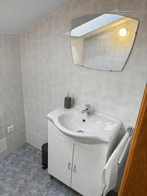 a white bathroom with a sink and a mirror at Ruhige Dachwohnung mit Bergblick - Passeiertal in Saltusio