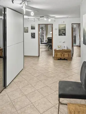 a living room with white walls and a tile floor at Ruhige Dachwohnung mit Bergblick - Passeiertal in Saltusio