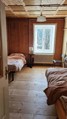 a bedroom with two beds and a window at Majon jal Toni in Vigo di Fassa