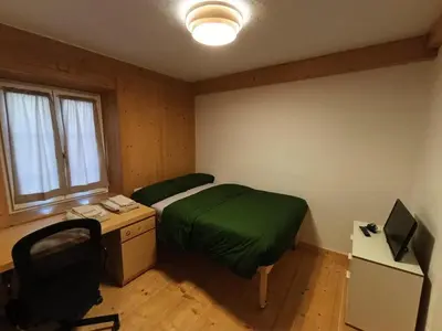 a bedroom with a bed and a desk with a computer at Majon jal Toni in Vigo di Fassa
