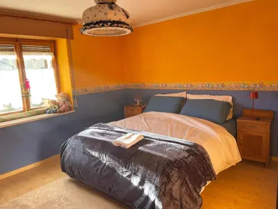 a bedroom with a bed with an orange wall at Appartamento Agordo in un borgo antico in Agordo