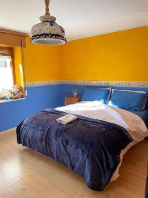 a bedroom with a bed with a blue and yellow wall at Appartamento Agordo in un borgo antico in Agordo
