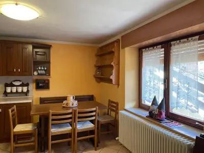 a kitchen with a table and chairs and a window at Appartamento Agordo in un borgo antico in Agordo