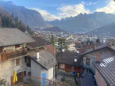 a city with houses and mountains in the background at Appartamento Agordo in un borgo antico in Agordo