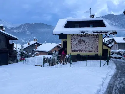 a building with a sign on it in the snow at Appartamento Agordo in un borgo antico in Agordo