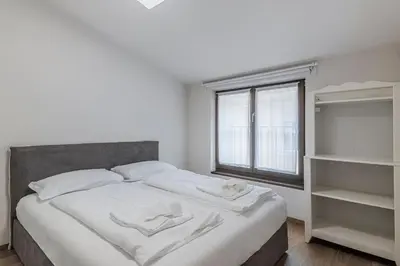 a bedroom with a bed with white sheets and a window at Stay COOPER l MAVIK Suite & Attic in Bolzano