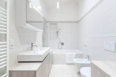 a white bathroom with a sink and a bath tub at Stay COOPER l MAVIK Suite & Attic in Bolzano