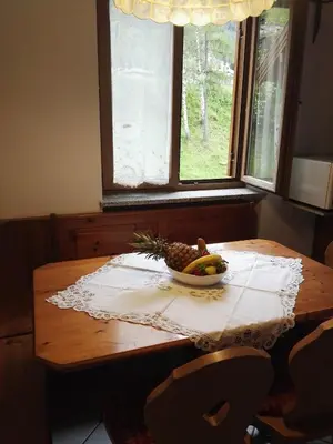 a bowl of fruit on a wooden table with a window at Casa Sergio in Ziano di Fiemme