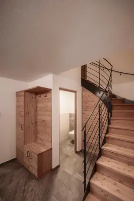 a staircase in a house with a wooden wall at Deluxe Apartments Lantl in Falzes