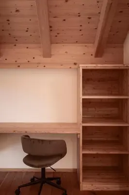 a desk and a chair in a room with wooden ceilings at Deluxe Apartments Lantl in Falzes