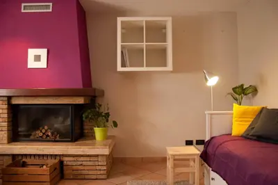 a living room with a fireplace and a red wall at Casa Dolci by Sunhome Fiemme in Tesero