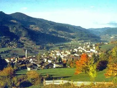 a town on a hill with mountains in the background at Casa Dolci by Sunhome Fiemme in Tesero